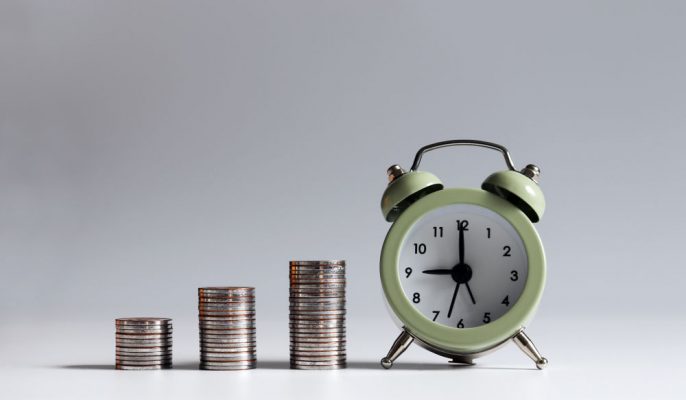 An,Alarm,Clock,And,Three,Stack,Of,Coins.